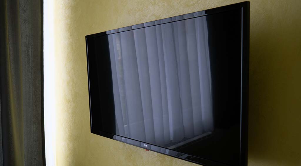 Televizorom sa kablovskim programima u motelskoj sobi